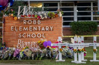 A memorial is seen surrounding the Robb Elementary School sign following the mass shooting at Robb Elementary School on May 26, 2022 in Uvalde, Texas. According to reports, 19 students and 2 adults were killed, with the gunman fatally shot by law enforcement.