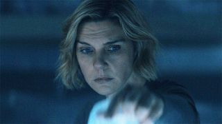 Carol lifting up a plastic sheet in a dark room in Pluribus episode 5