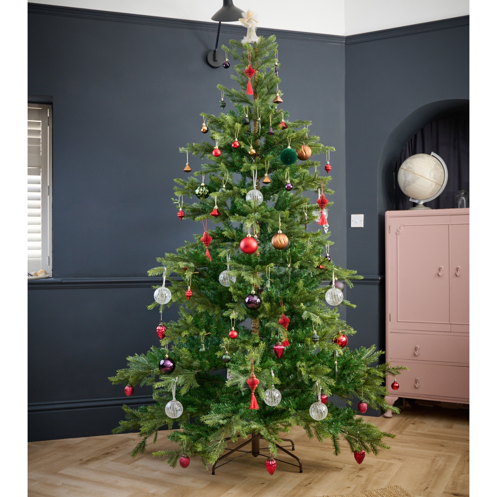 The White Company's 7.5ft Grand Spruce Christmas Tree decorated with Christmas baubles in a black-painted living room
