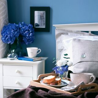 bedroom with side table and blue wall