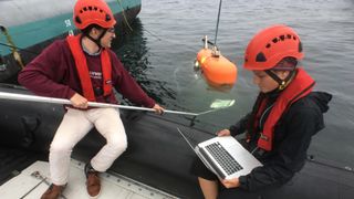 NASA JPL engineer Russel Smith and WHOI engineer Molly Curran calibrate Orpheus’s cameras prior to its first-ever dive in 2018..