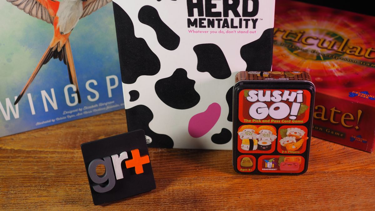 A collection of games (Wingspan, Herd Mentality, Sushi Go, and Articulate) on a wooden table in front of a GR+ logo