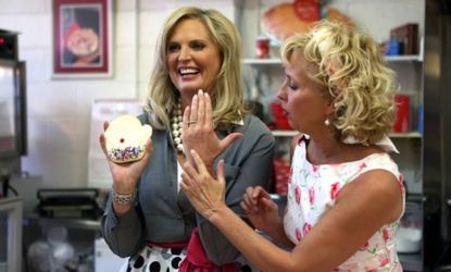 Ann Romney, seen here with a local Michigan bakery owner, shows off a mitten-shaped cookie