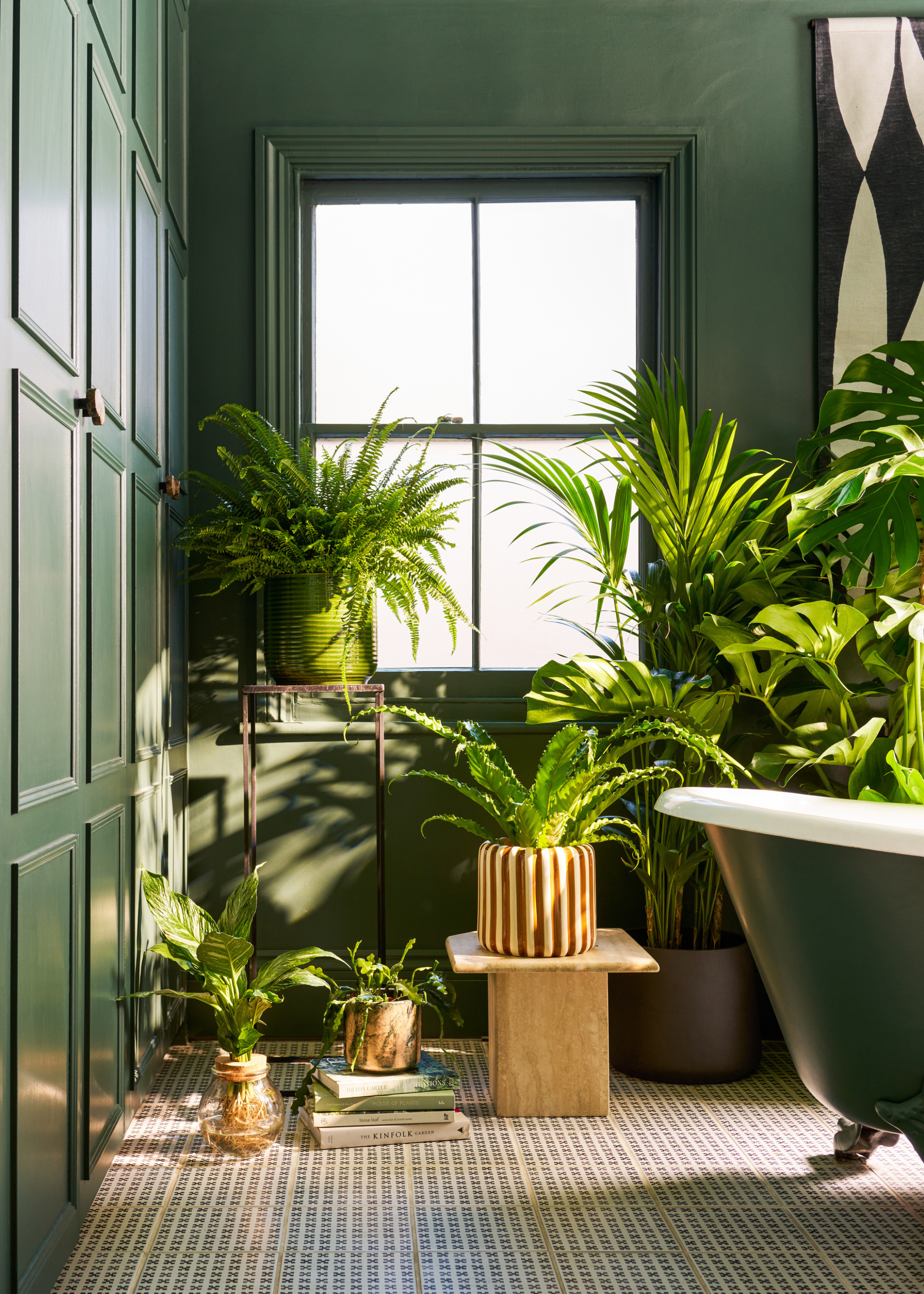 A green bathroom with potted ferns and houseplants