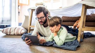 Dad and child playing on a tablet