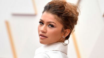 zendaya close up at the 2022 oscars in a cropped white button up and soft updo