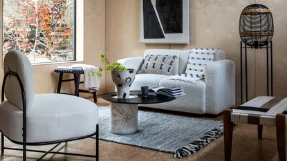 Living room with white boucle sofa, table, rug