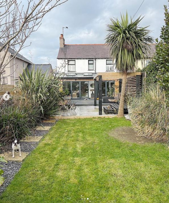 A view of the back of the house with lawn and patio