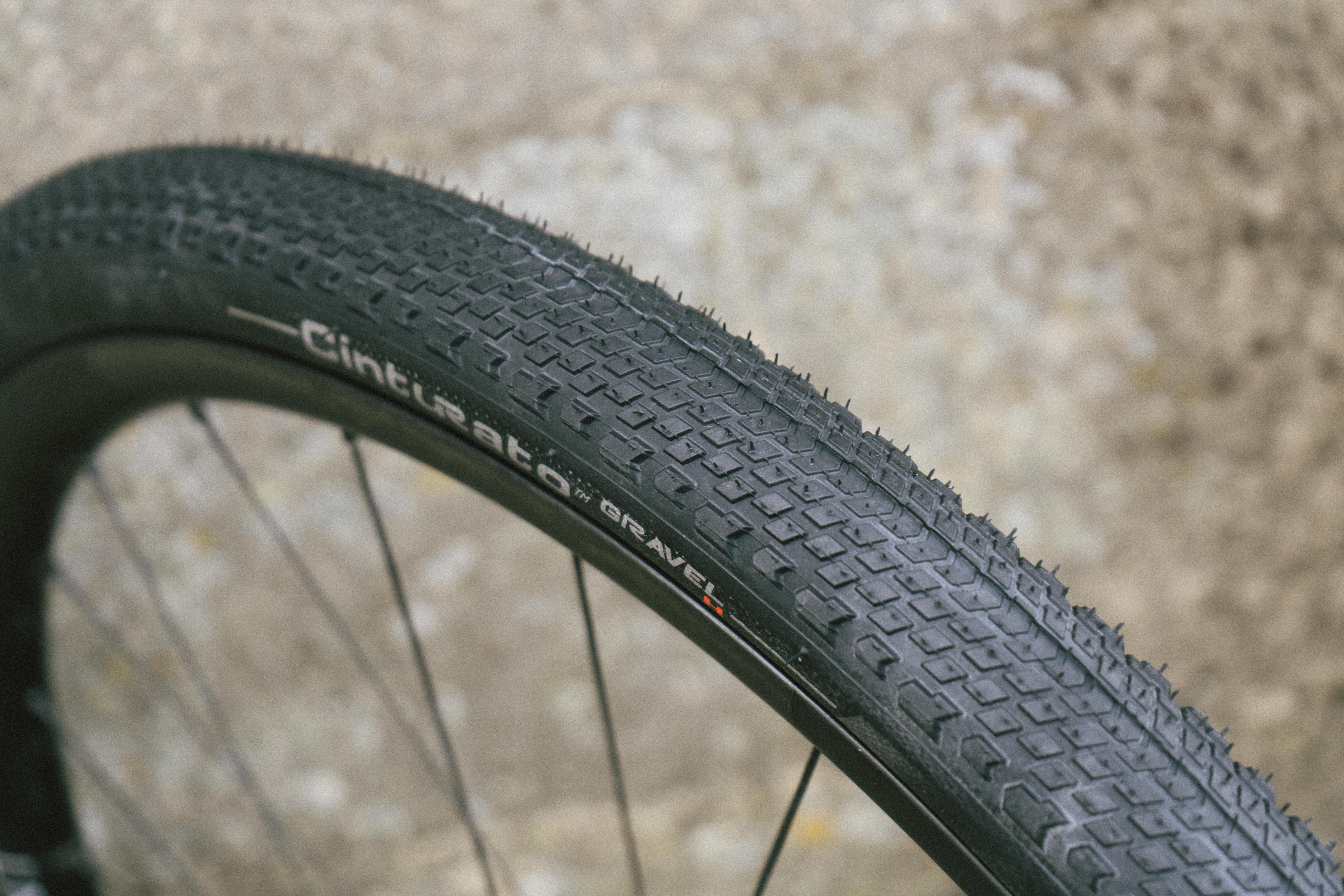 A black gravel tyre against a stone wall