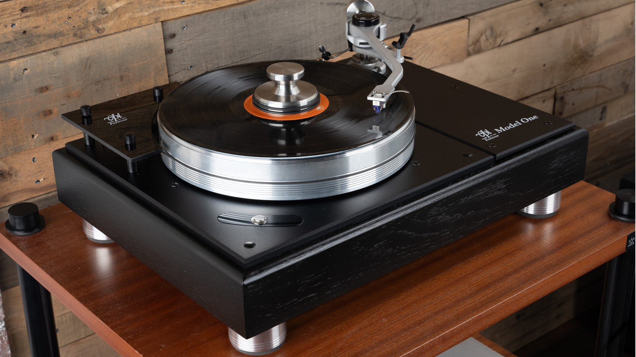 The VPI Model One turntable sitting on top of a wooden unit in front of a wood-panelled wall