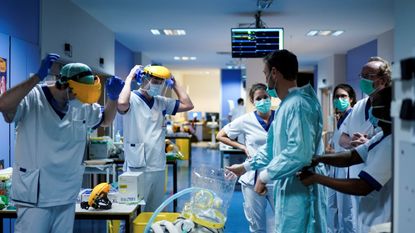 Medical workers put on their protective gears before working at the Erasme Hospital in Brussels.