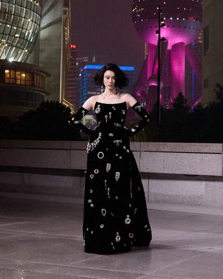 Model walks Balenciaga runway in dress covered in jewellery with Shanghai skyline in backdrop