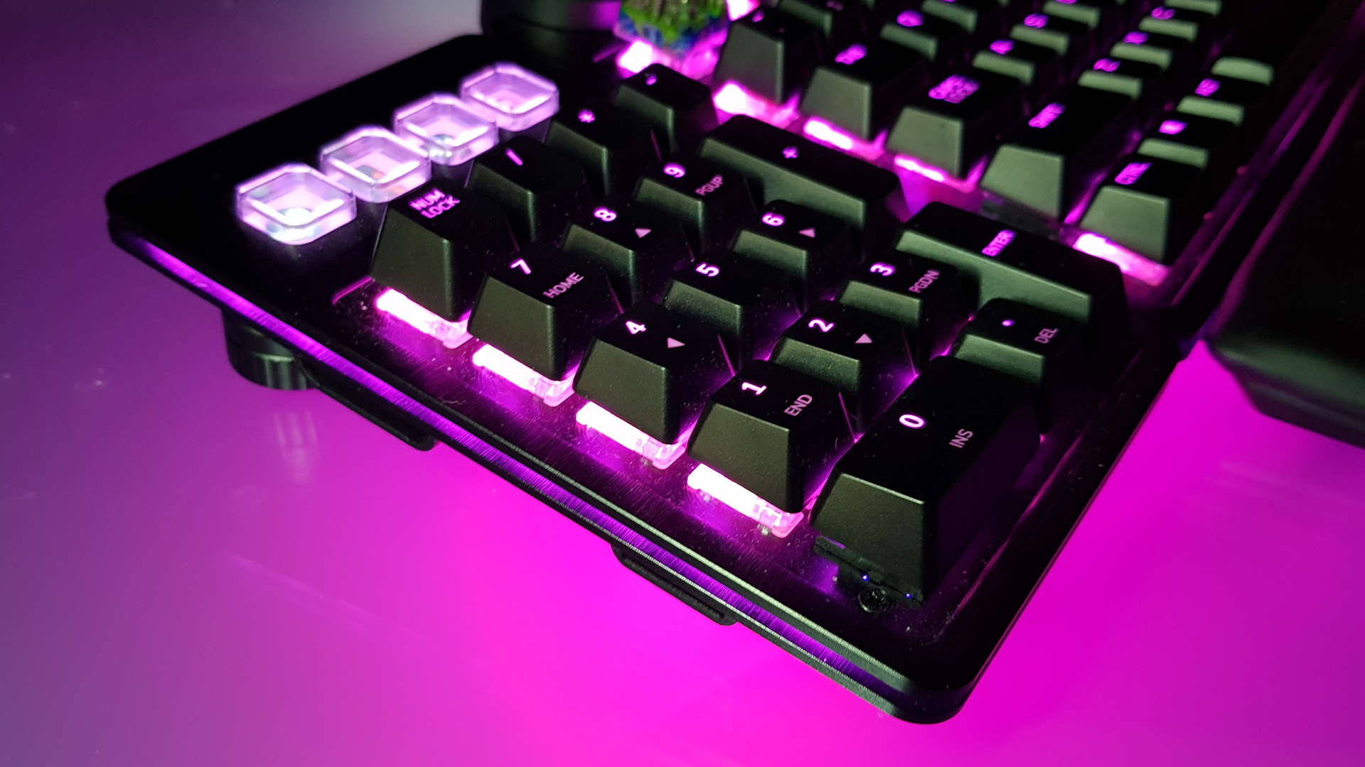 Крупный план съемной цифровой клавиатуры Mountain Everest Max на фиолетовом фоне.