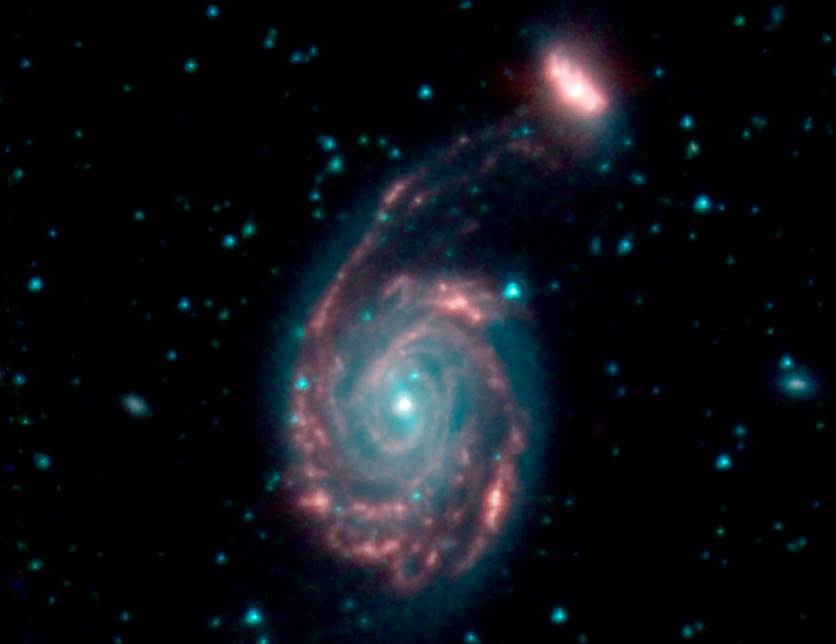 The merging galaxies NGC 7752 (larger) and NGC 7753 (smaller), collectively called Arp 86. Blue and green represent wavelengths of light strongly emitted by stars, while red shows a wavelength mostly emitted by dust.