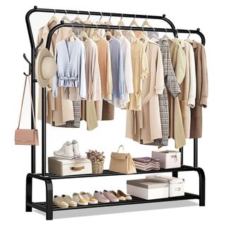 A black clothes rail with shirts, jackets, hats, bags and shoes in neutral colors