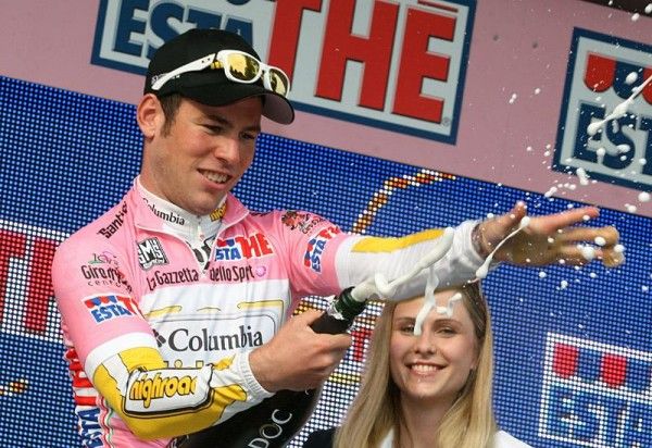 Mark Cavendish uncorks the bubbly to celebrate donning the race leader's maglia rosa.