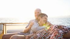 Affectionate senior couple on a boat trip at sunset 