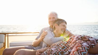 Affectionate senior couple on a boat trip at sunset 