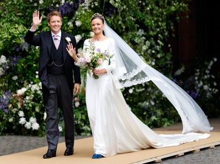 The Duke and Duchess of Westminster smiling and waving on their wedding day in June 2024