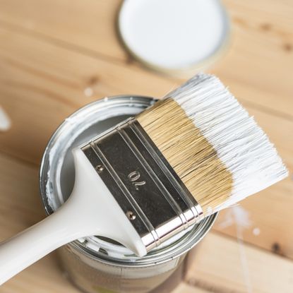Paint brush dipped in paint pot
