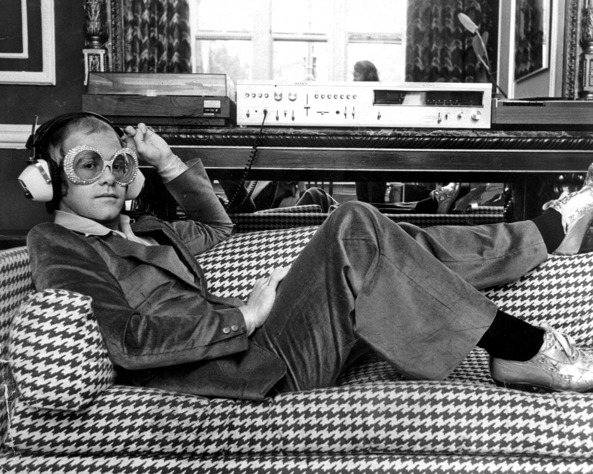 elton john on a houndstooth sofa