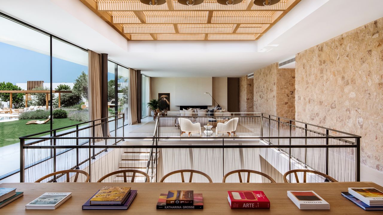 A view of an open plan dining and living area in an Ibiza villa with sunken staircase