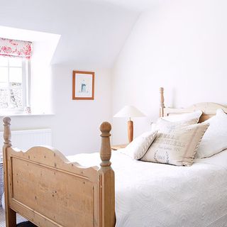 guest bedroom with wooden bed and white bedlinen