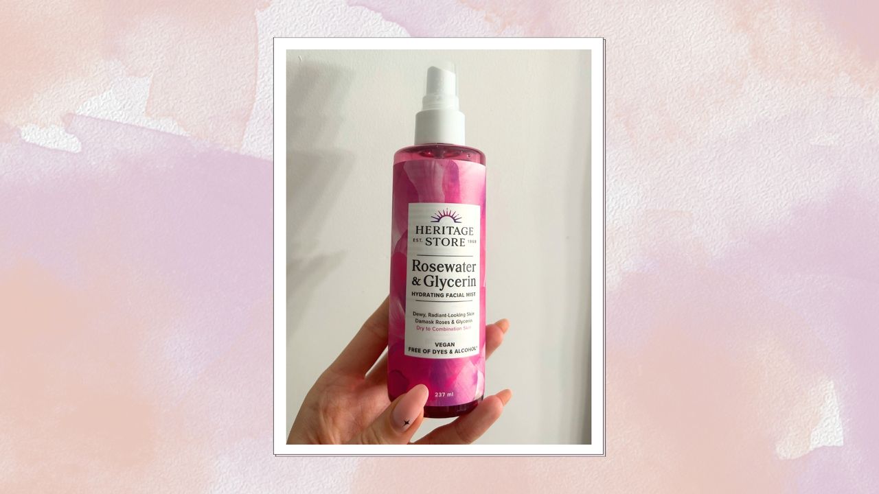 Image of hand holding Heritage Store&#039;s Rosewater Spray on a pink and purple watercolour background