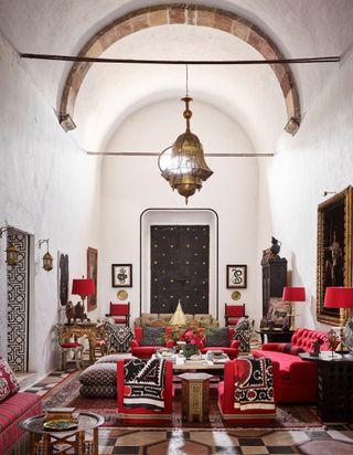 Red upholstery, red lampshades, dark wooden door with gold fixtures