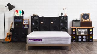 Purple vs Nectar: The Purple Hybrid mattress placed in a bedroom filled with speakers and a guitar