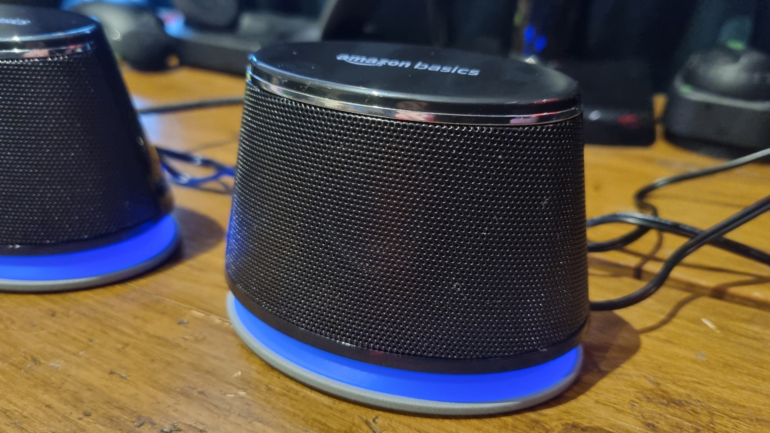 A close up of a single Amazon Basics Stereo speaker, with the RGB lighting lit in blue