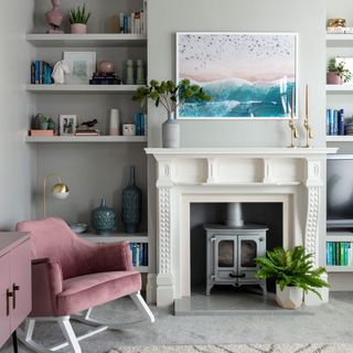 living area with shelves and fireplace and armchair
