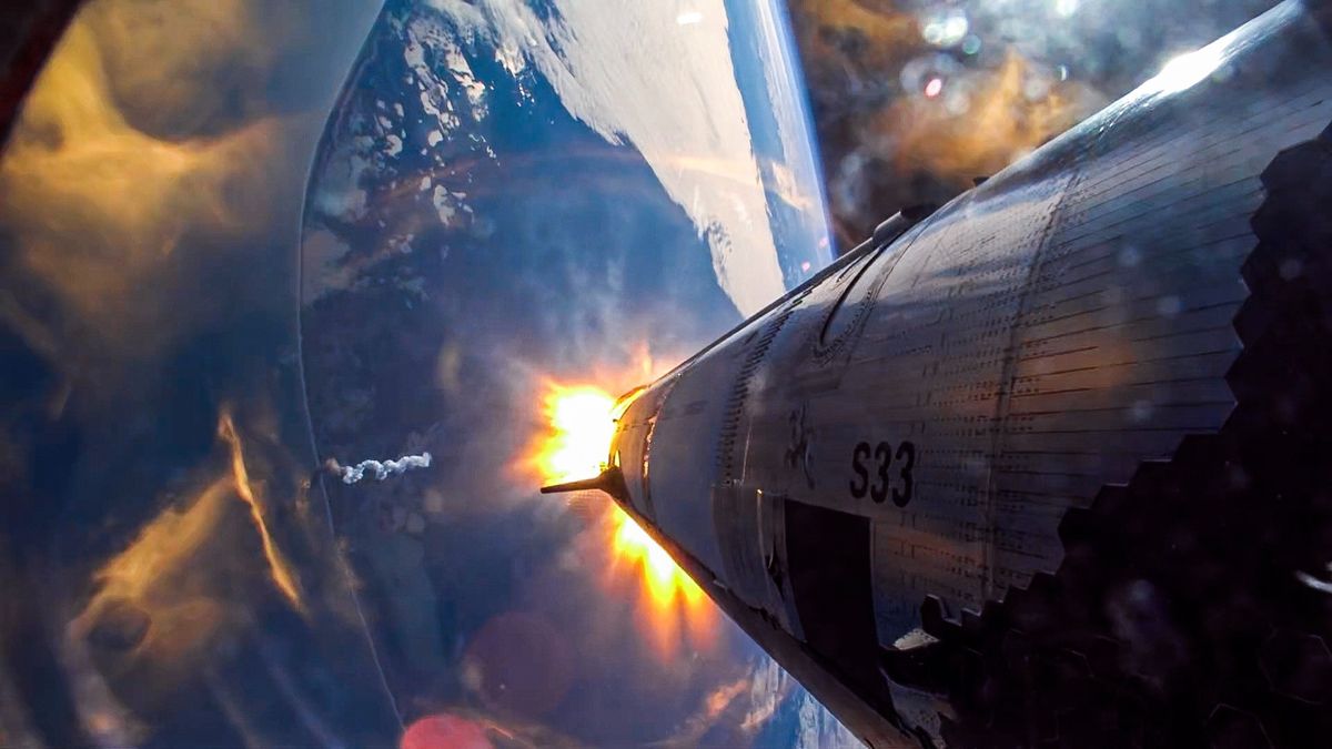 the blues and whites of earth can be seen in the background while a silver-and-black cylindrical rocket takes up the right side of the image