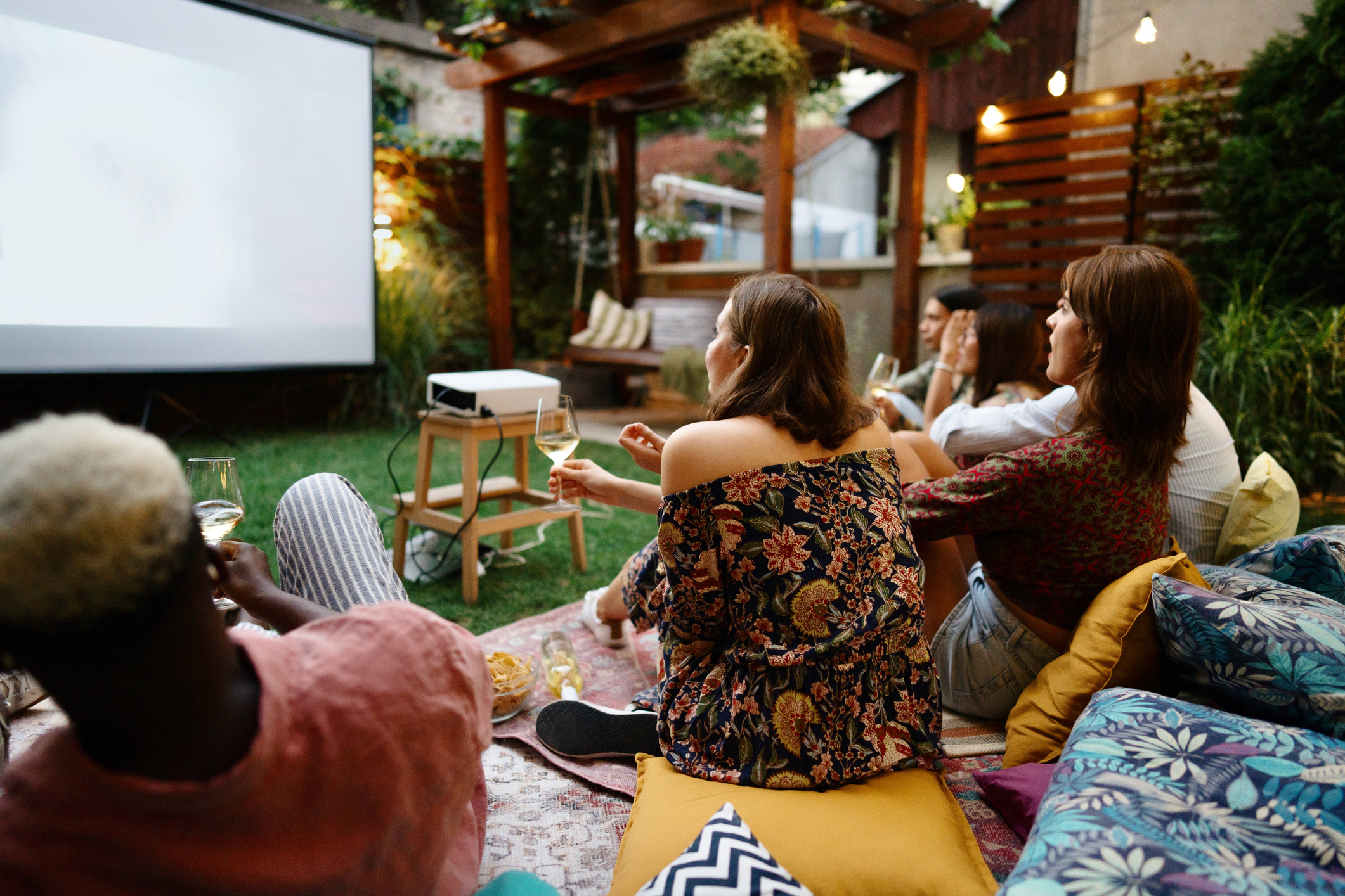 Modern friends watching movies in the backyard