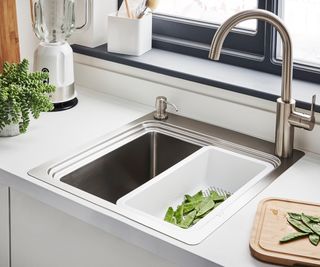 A small stainless steel workstation sink with a veg washing attachment