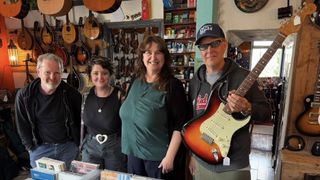 Joe Bonamassa poses with the Fender Strat he purchased at the shop where Rory Gallagher bought his famed 1961 Fender Strat. He's standing with the store's staff
