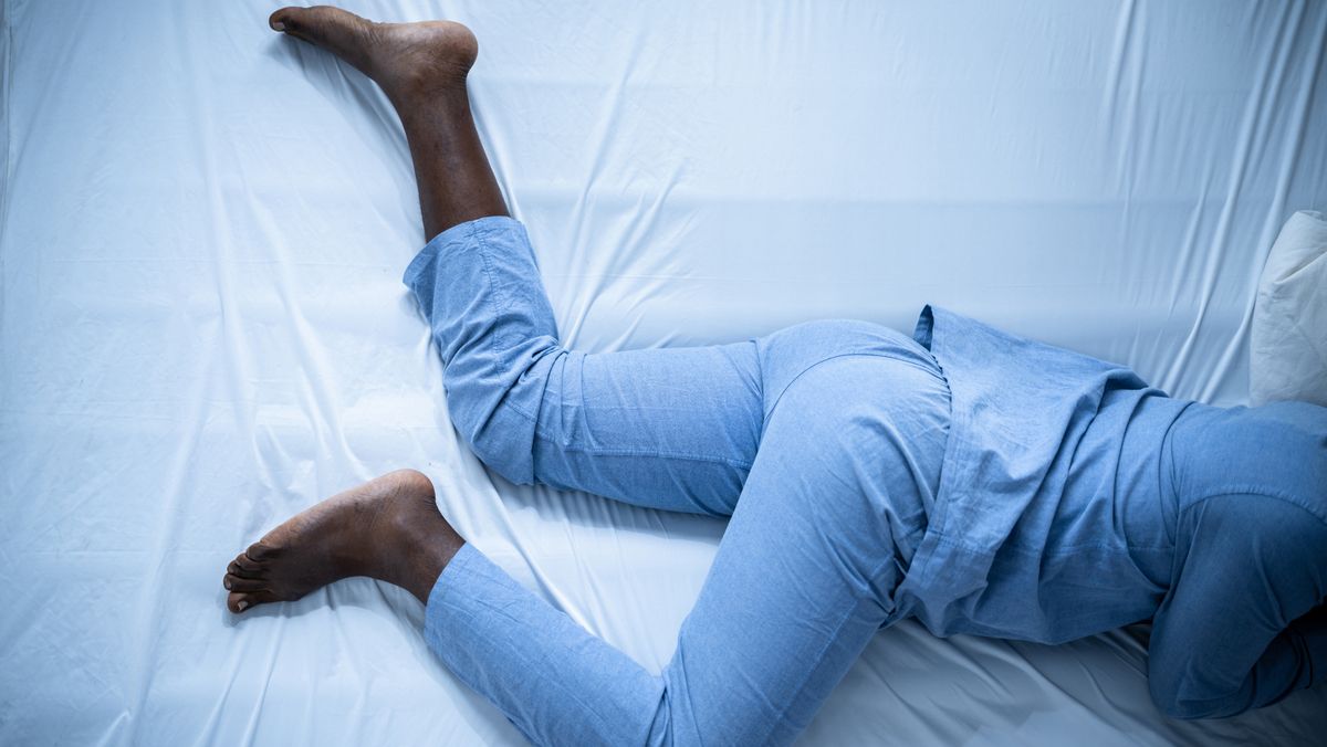 A man struggles with restless leg syndrome at night as he tries to fall asleep at night