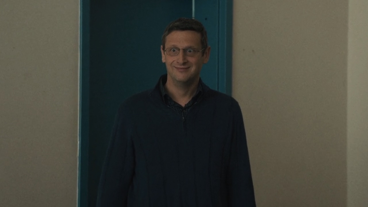 Ron smiling after finding room full of Tecca chairs in The Chair Company Episode 6