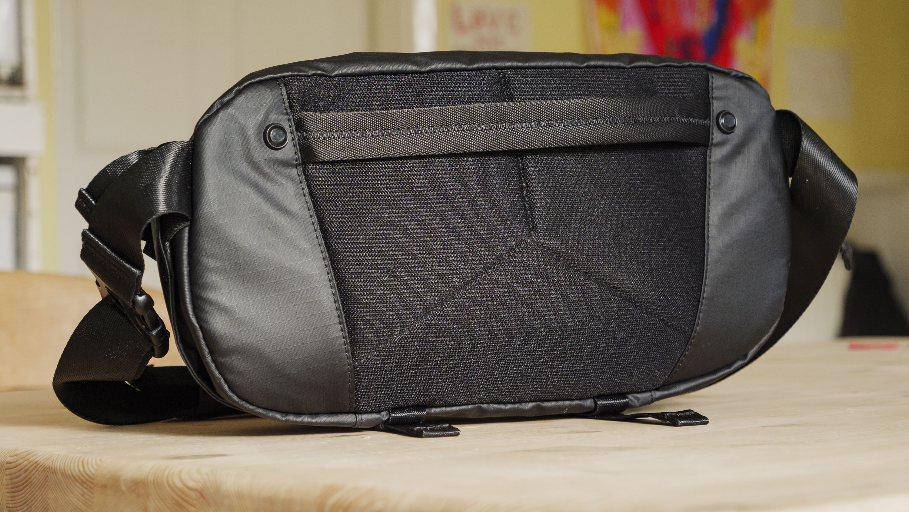 The Ulanzi Camera Sling Bag on a wooden table, back