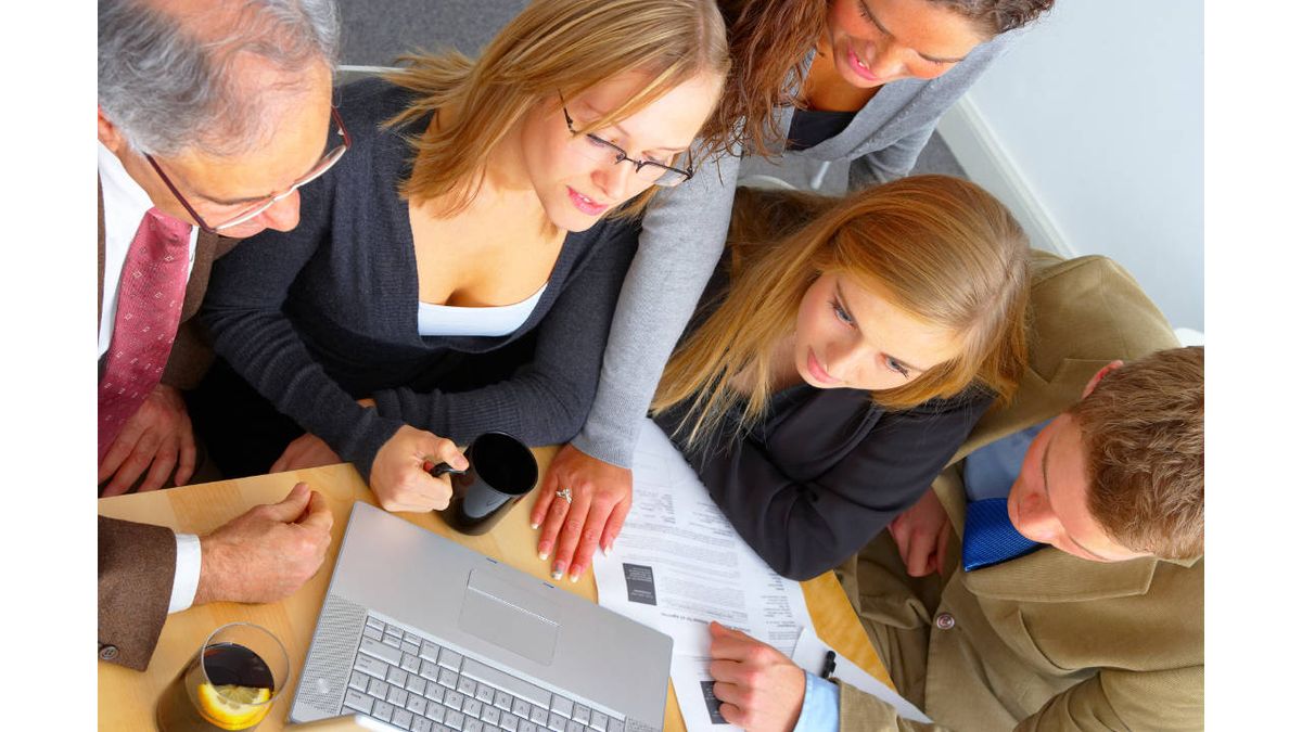 educators gathered around a laptop computer