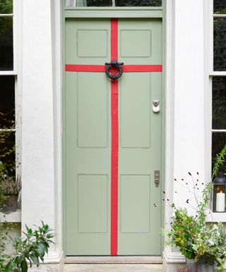 Lichen green front door with red braid. Front door dressed as a gift.