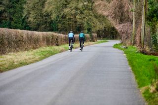Image shows two riders cycling in the winter.