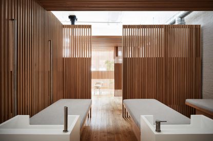 Hair washing area at Spiral (x,y,z) featuring semi-transparent wood slats, hair-washing beds and white hair washing units