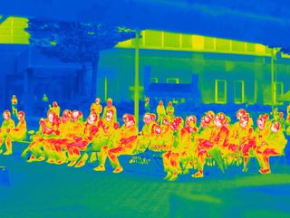 Heat map style photograph of people sitting on chairs.
