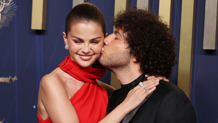 Selena Gomez in red halter dress getting kissed by Benny Blanco at the 77th Emmy Awards.