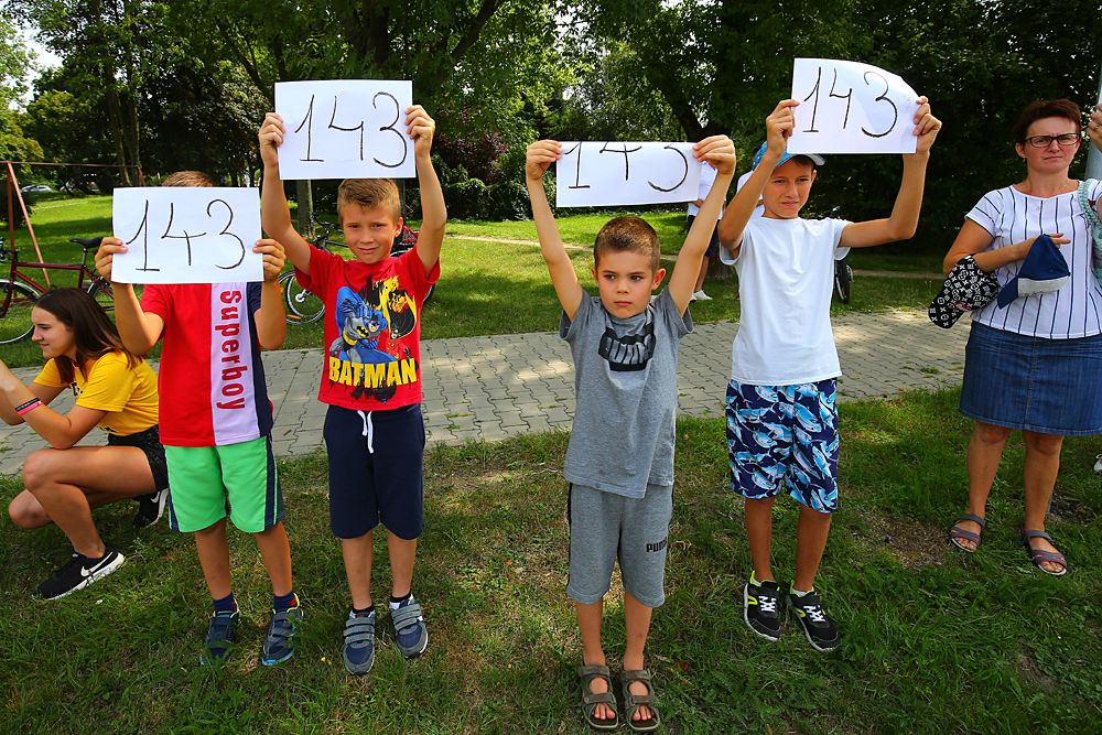 Fans wave Bjorg Lambrecht's bib no. 143 during the neutralised Tour de Pologne stage 4
