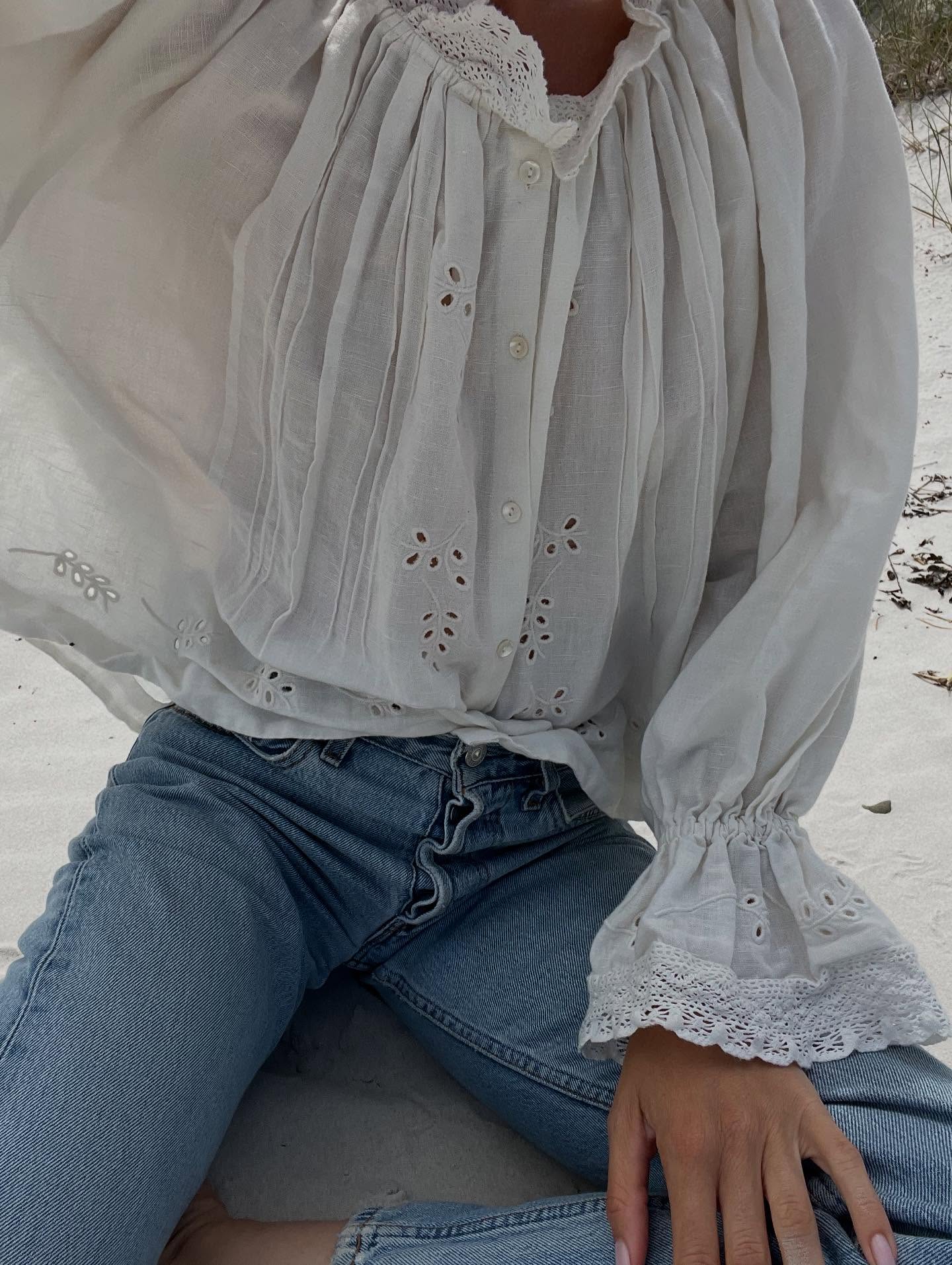 An image of a woman wearing a blouse and jeans summer outfit 2026