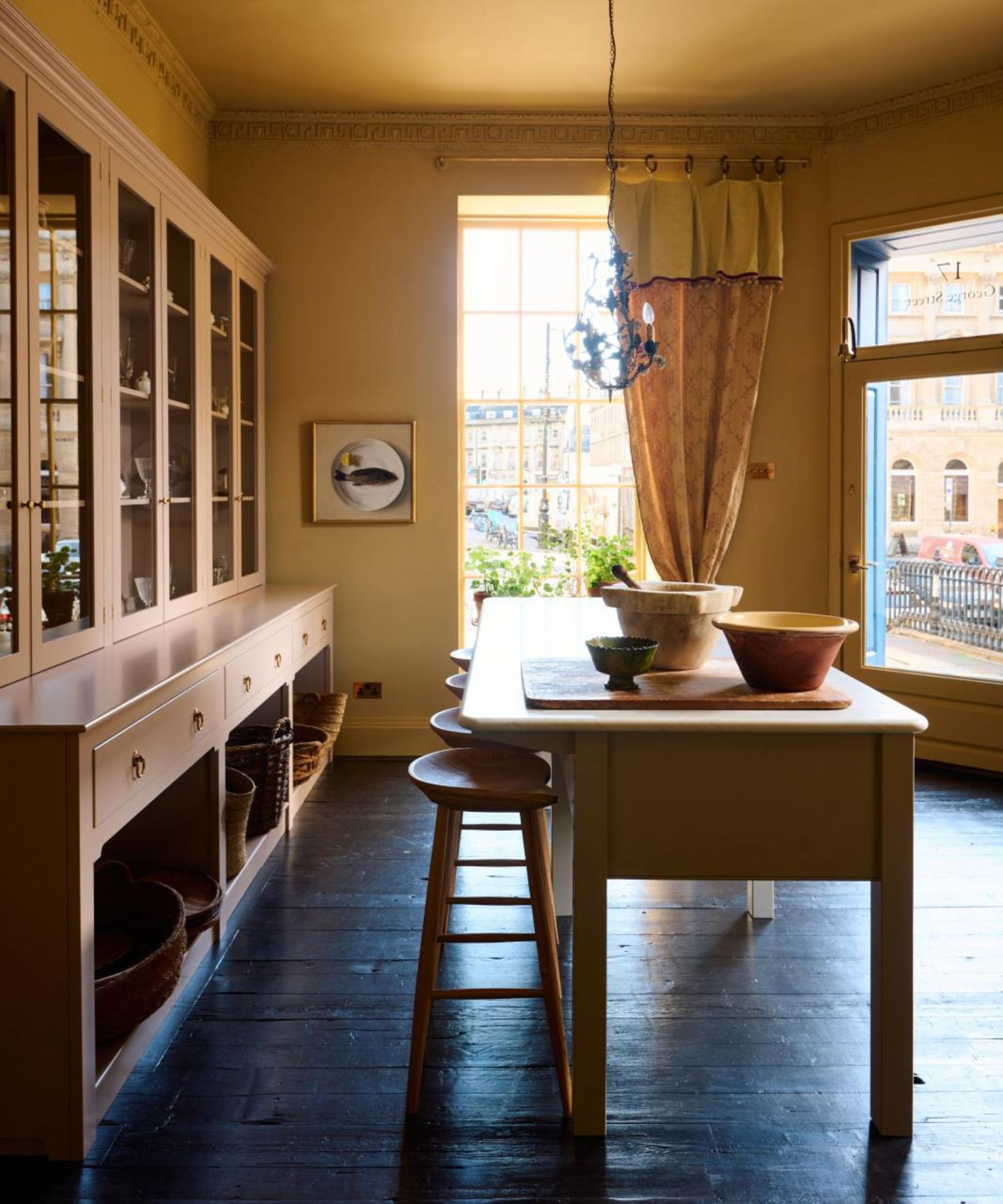 Yellow kitchen with dark wooden floor and kitchen island