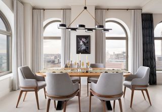 a dining room with arched windows with curtains