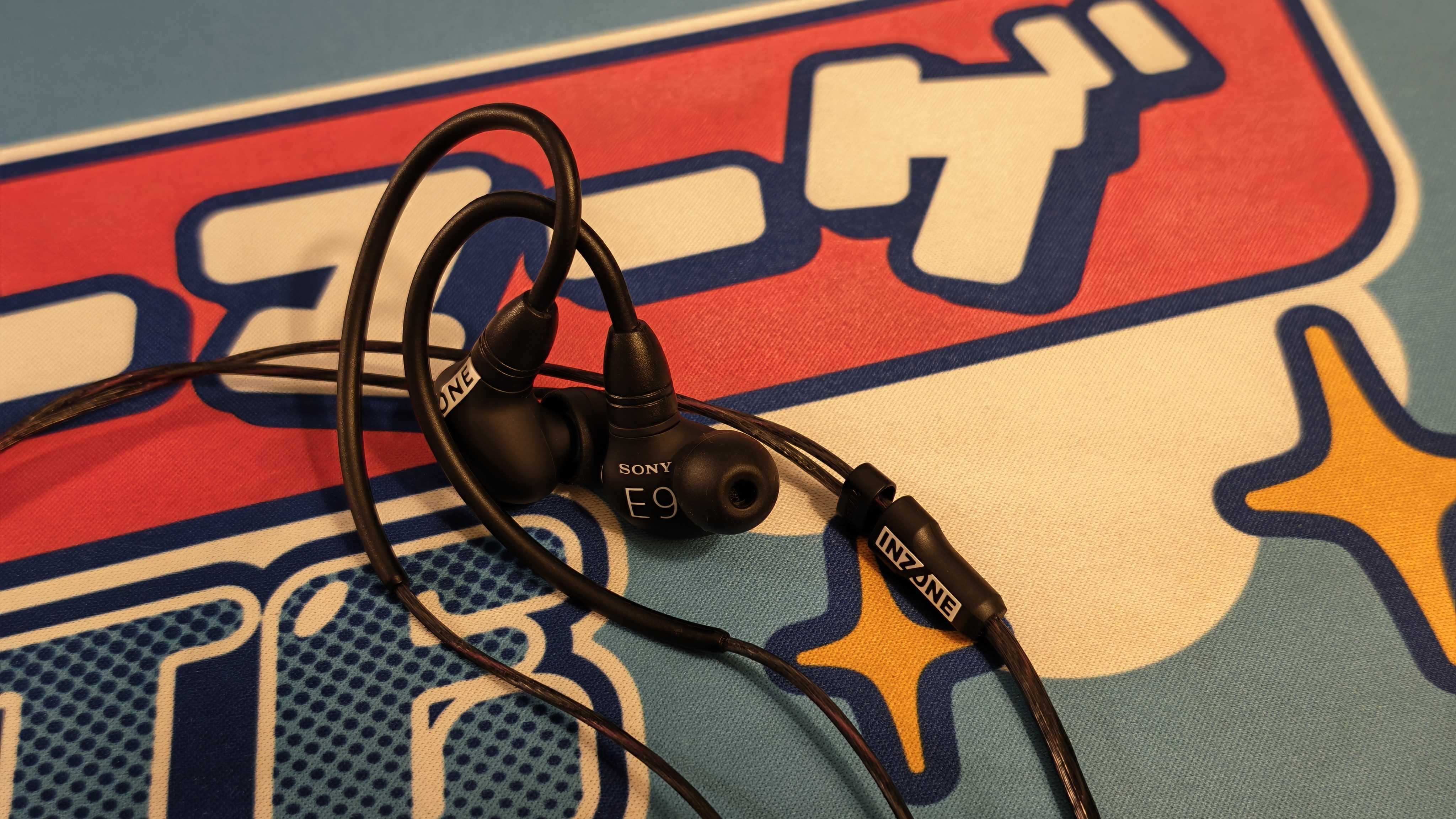 The Sony Inzone E9 gaming earbuds on a colorful desk mat.